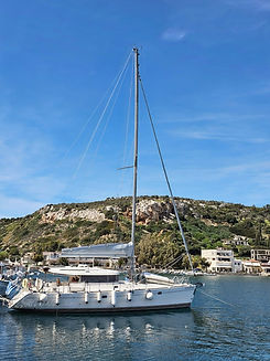 Luxury sailboat docked in harbor, sunny day