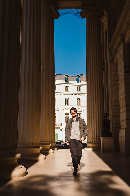 Traveler walking between the columns of the Romanian Athenaeum during a cultural photo walk in Bucharest
