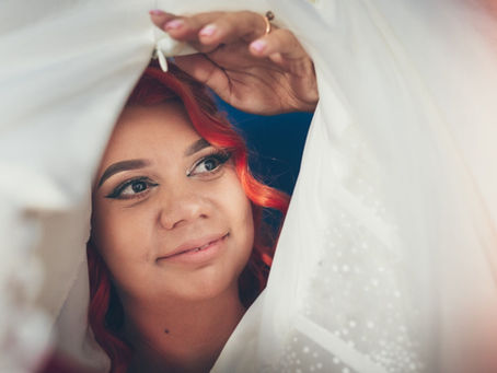Mireasă privind prin voal în timpul pregătirilor de nuntă la Kaia Events Barn