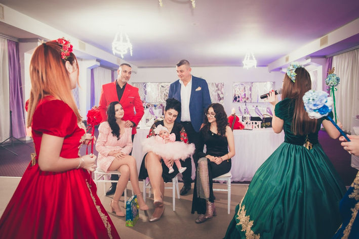 Invitați, familie și ursitoare la petrecere de botez în București.
