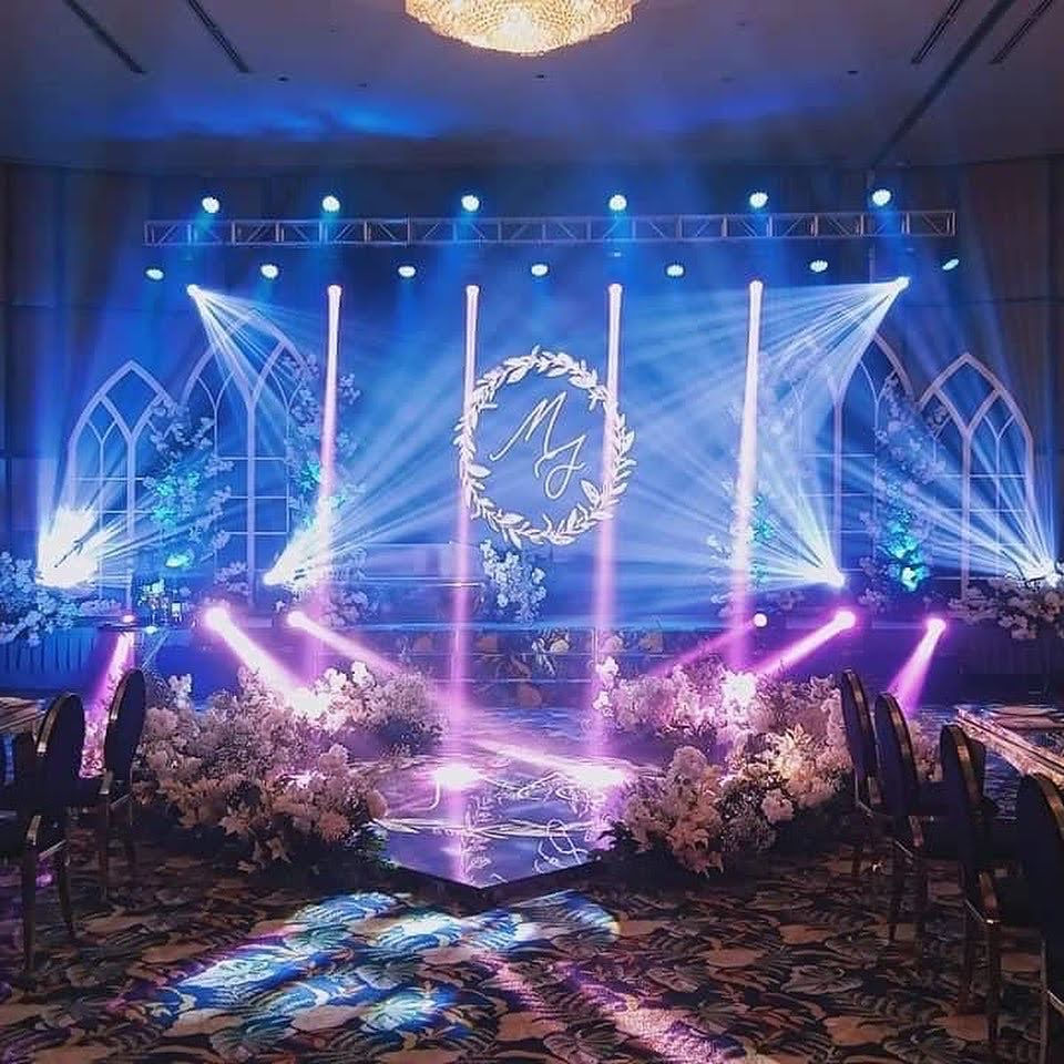a stage is decorated with flowers and lights for a wedding reception .