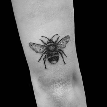 fine line bee tattoo on tricep