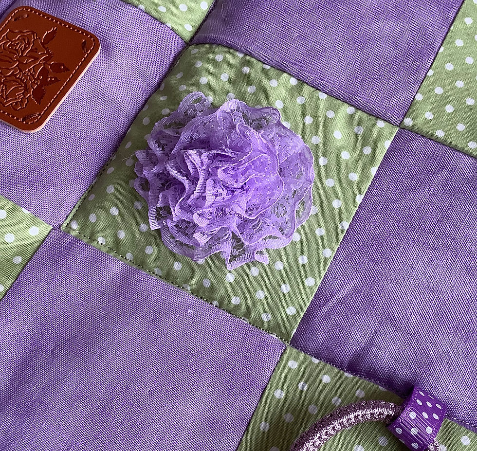 Thumbnail: Purple ruffled fabric flower on a green polka dot panel.