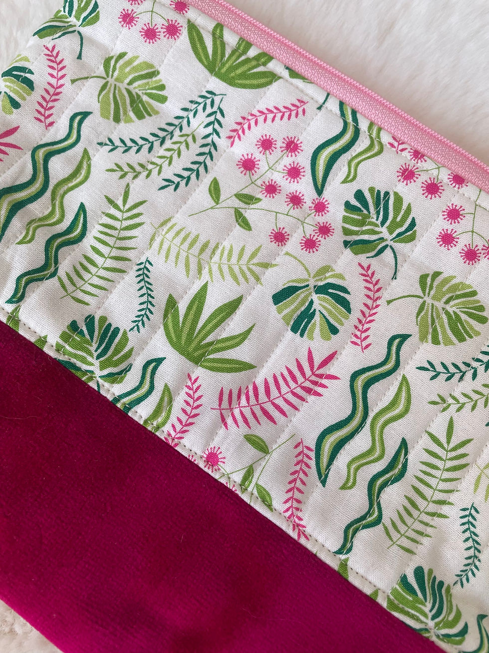 Thumbnail: Handmade tropical leaf makeup bag with a burgundy suede base, on a soft fleece.
