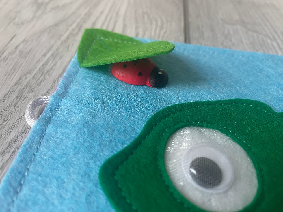 Thumbnail: Felt leaf lifted to reveal hidden animal charm on handmade chameleon busy book page, discovery activity for toddlers