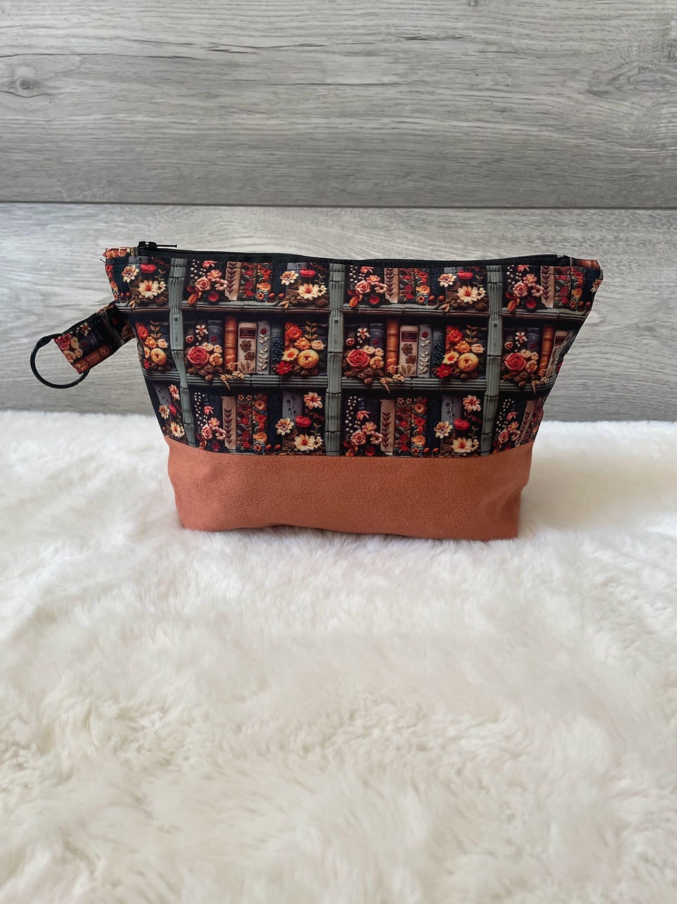 Thumbnail: Handmade book-print makeup bag with a rust suede base, side view.