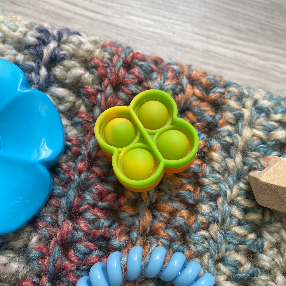 Thumbnail: Close-up of sensory attachments on handmade twiddlemuff — pop-it, flower and beads, made in Ireland by The Owl Tree