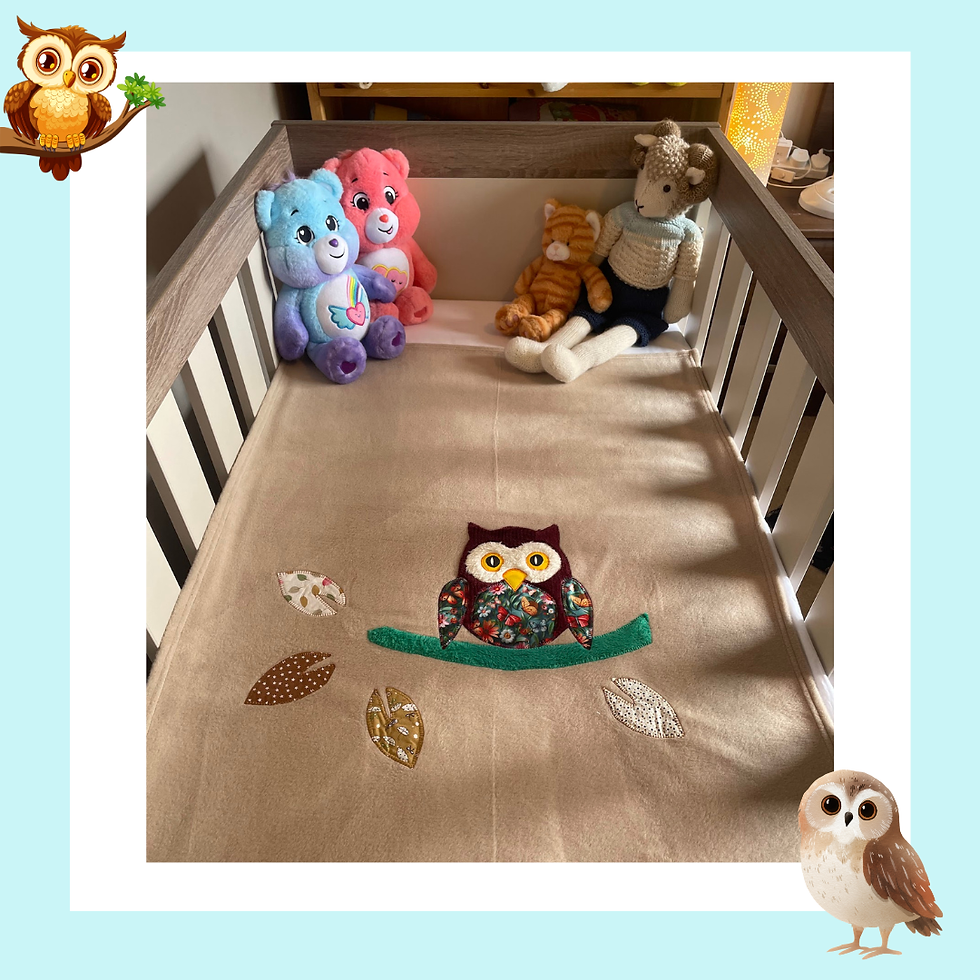 Handmade fleece blanket — Burgundy Owl on Beige, in crib with soft toys, made in Ireland by The Owl Tree