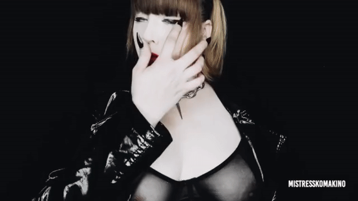 Mistress Komakino in a PVC jacket and transparent bra holding her breasts and shoving poppers on the screen