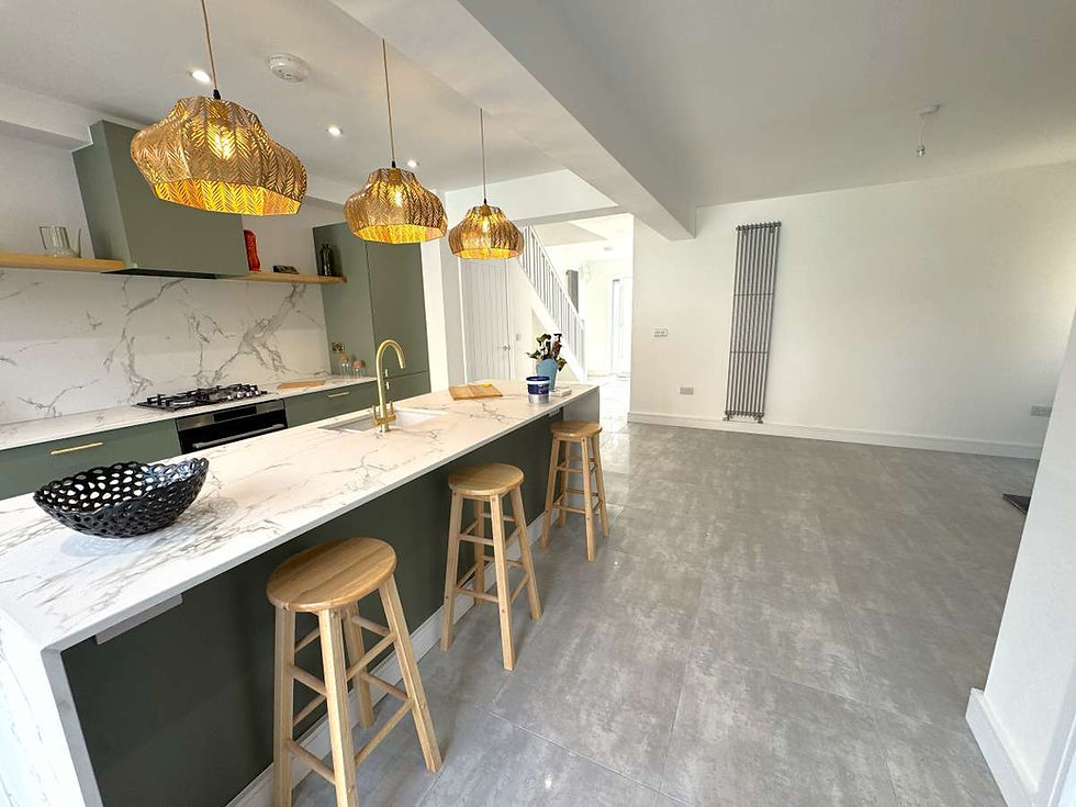 Modern open-plan kitchen in a refurbished Filey home with a marble-effect island, sage green cabinetry, woven pendant lights and oak bar stools