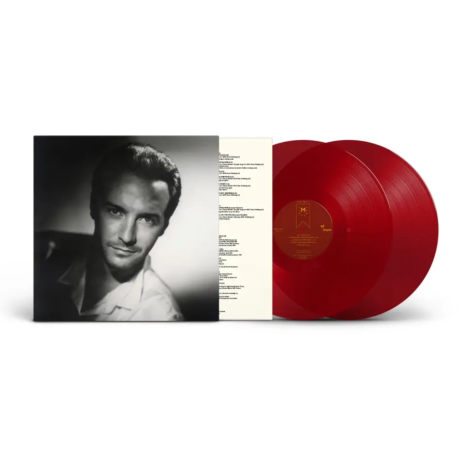 Midge Ure - The Gift album cover with red vinyl records protruding from the sleeve. The album cover displays and head of shoulders close up of Midge Ure with dark shadow the left side of his face.