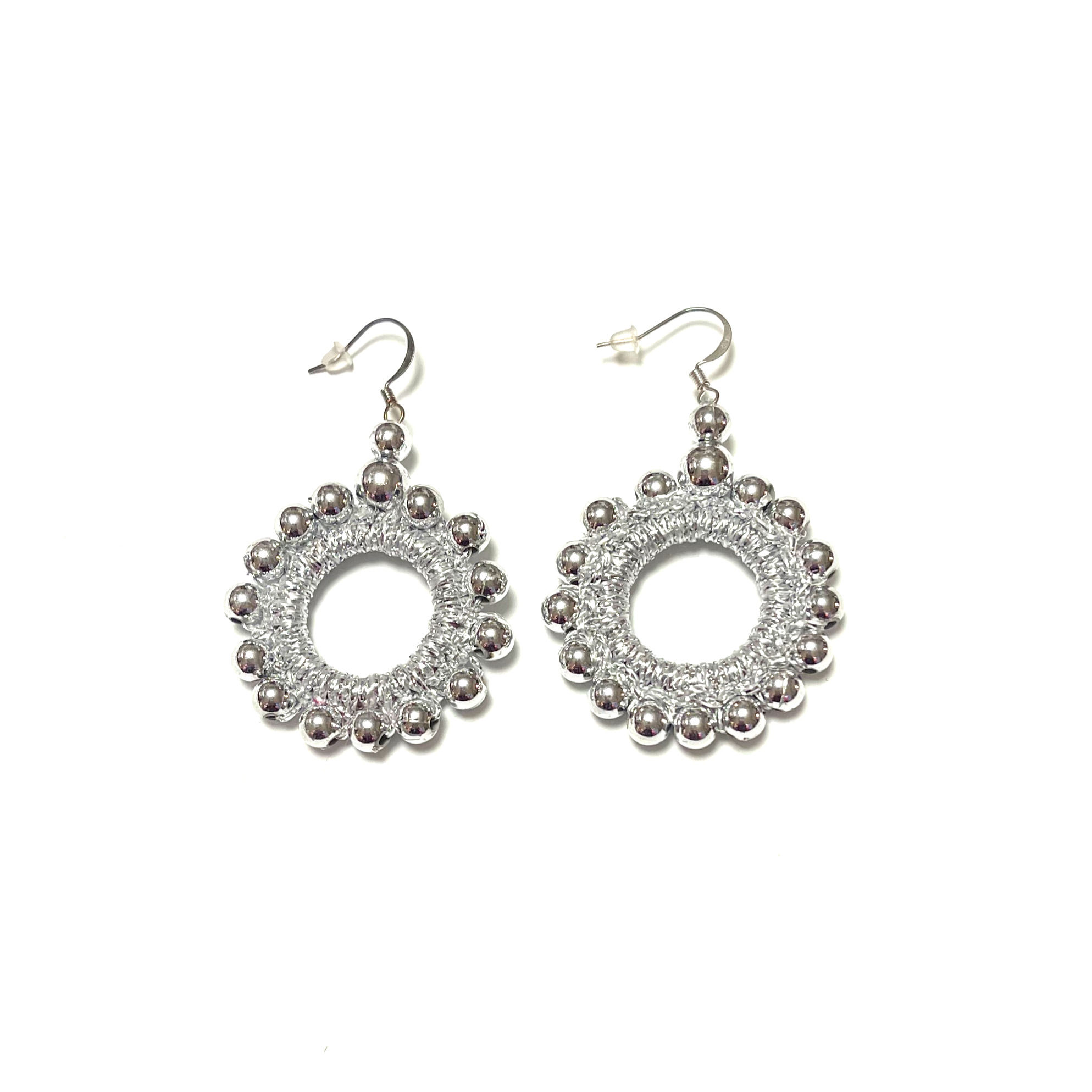 Round shimmering earrings decorated with meatalli beads. 