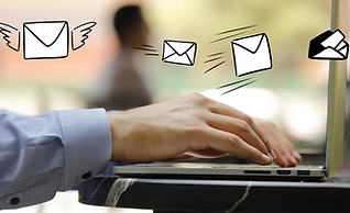 Man typing at a keyboard on a marble table with white cartoon envelopes flying above it