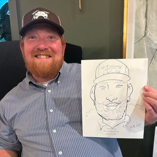 a red headed man gets a caricature by kathy at the barn at hope farms in Fairhope, AL at mosquito joes tenth anniversary party