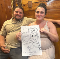 guests hold their wedding caricature by kathy buskett and smile at a wedding at the cedar post barn in Louisiana