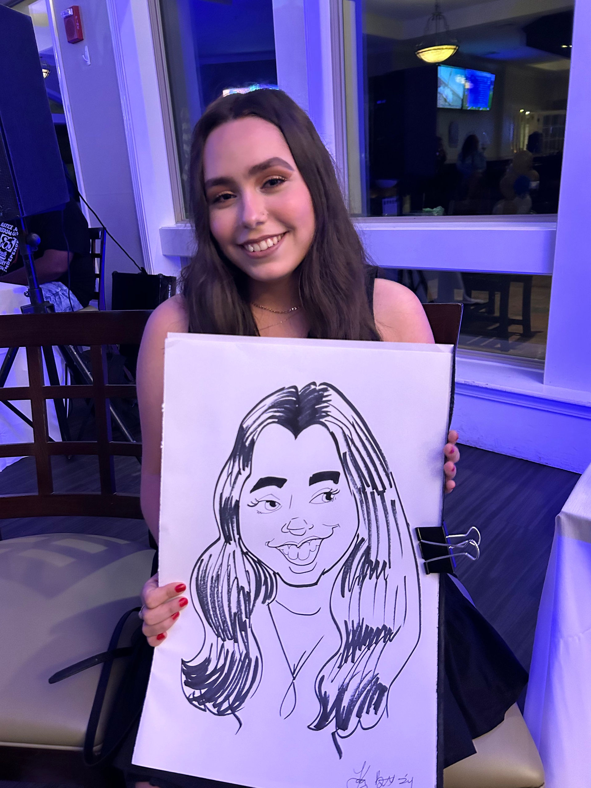 a young teen holds hewr caricature at a quinceanera in pensacola FL