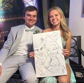 smiling couple at the prom holds their sketch