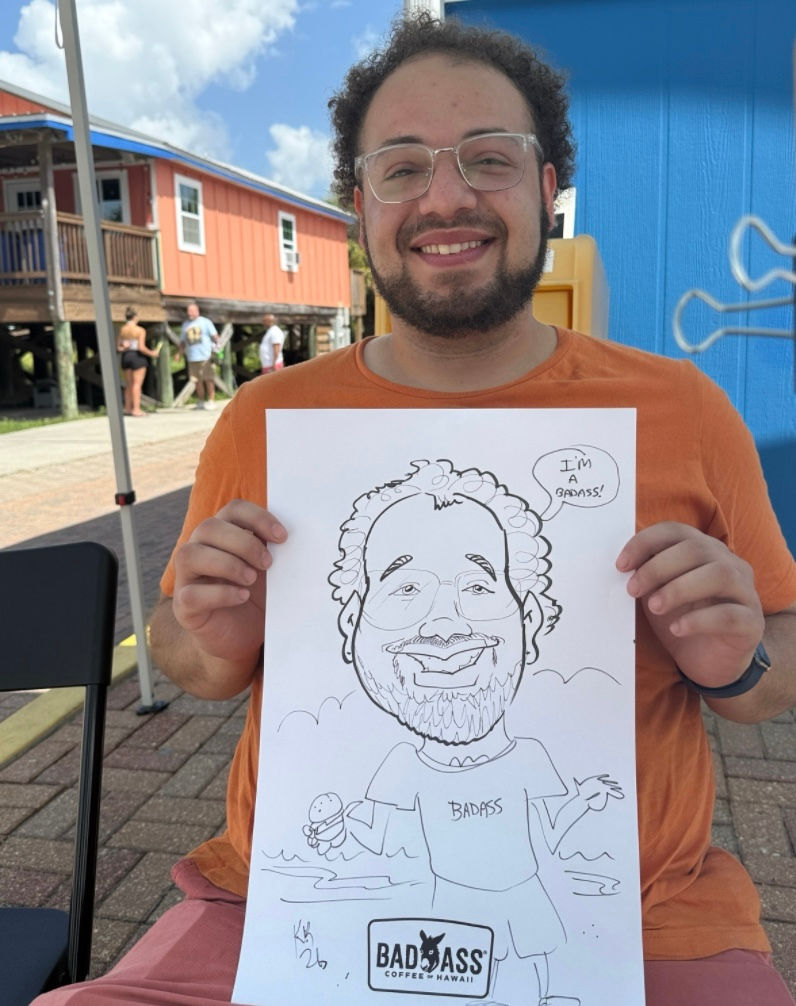 a man shows off his caricature at badass coffee grand opening in pensacola