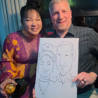 A couple gets a caricature by caricatures by kathy at an outdoor wedding at the oakes venue in Ponchatoula, LA spring 2025