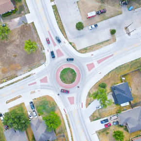 Cars move through a roundabout in a neighborhood