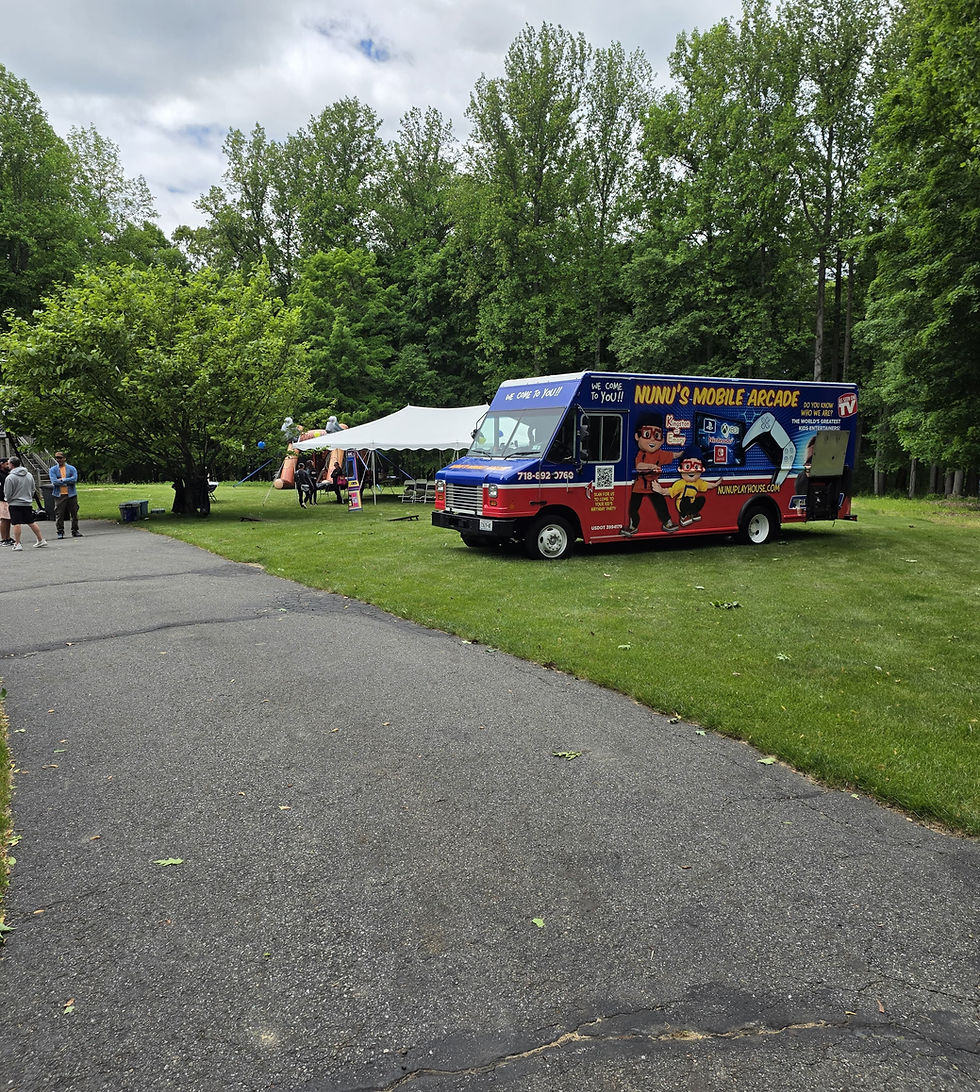 Eye-level view of a colorful mobile game truck parked in a suburban driveway