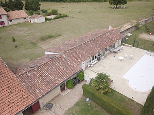 Vue d'une toiture en tuiles canal, presque propre après un nettoyage et traitement anti mousse par drone, près de Poitiers, dans la Vienne 86