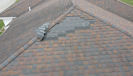 Roof with shingles blown off in need of repairs.