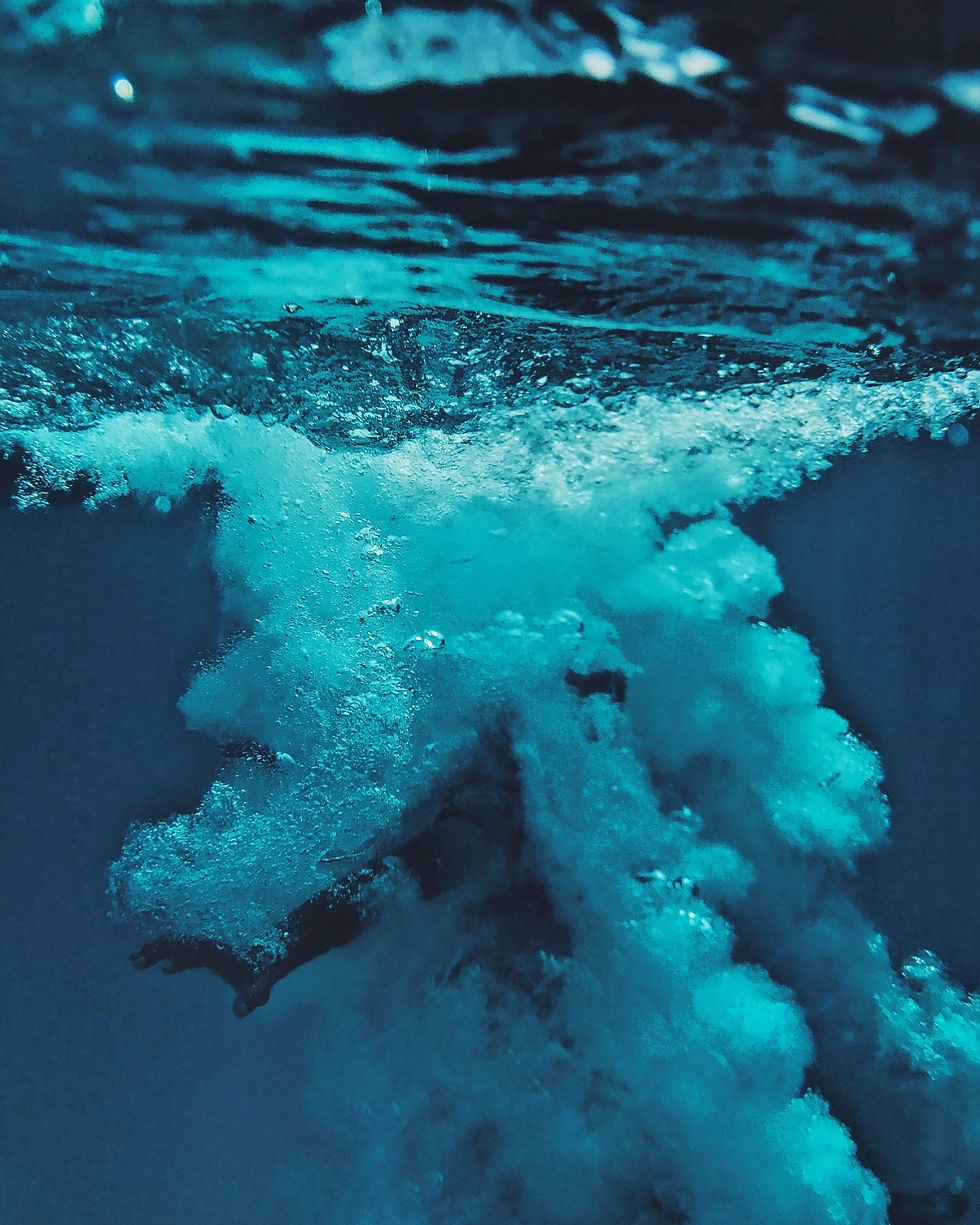 A person who has overcome fear is engulfed in bubbles after jumping into a pool.