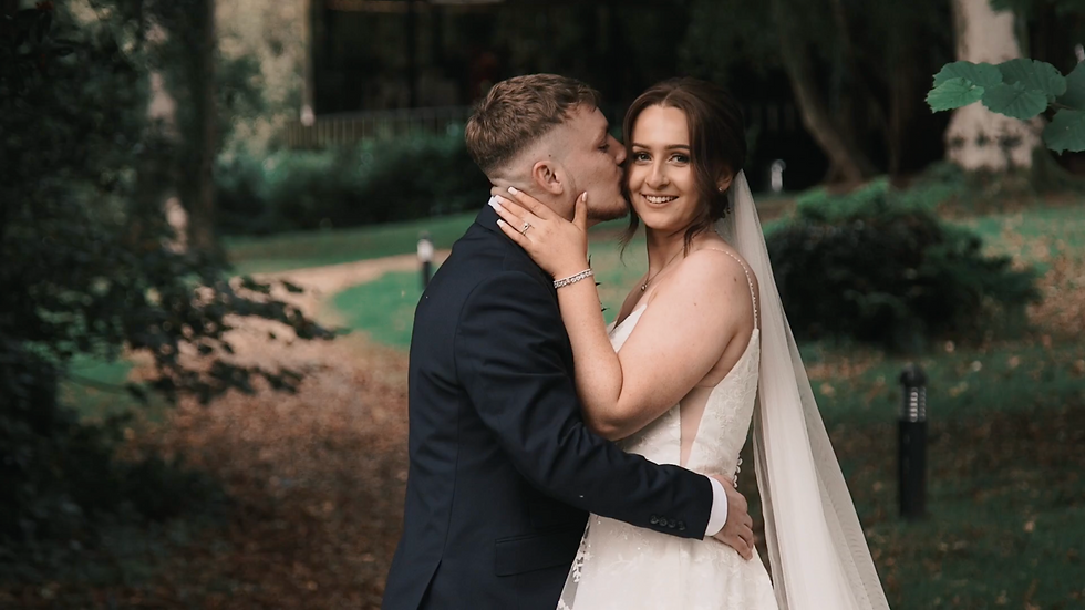 Bride and groom smiling at each other in the grounds at Fairyhill on the Gower after their wedding ceremony