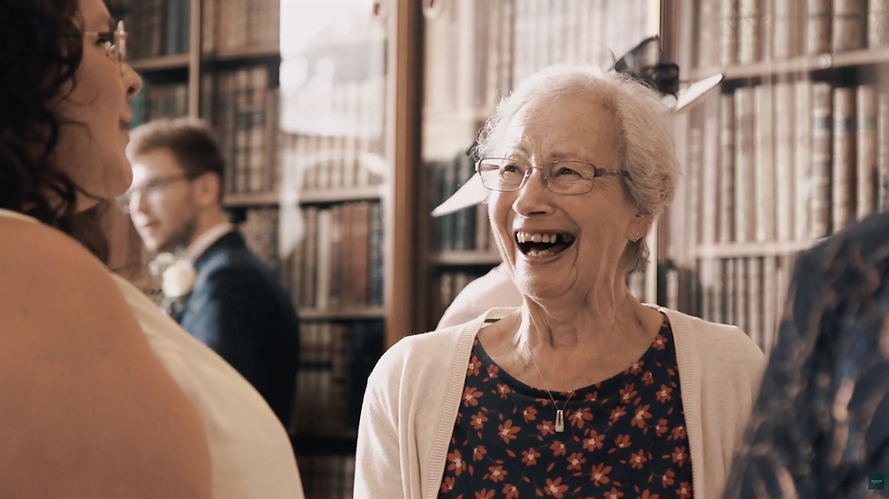 Grandmother laughing with guests in the library at a Staffordshire wedding