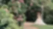 Bride and groom smiling beneath a vintage lamp post surrounded by pink flowers at Hawkesyard Estate, Staffordshire – filmed by Joe Felton Videography