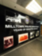 Wall mural at Milltown Police Department honoring years of dedicated service, featuring historical photographs, police badges