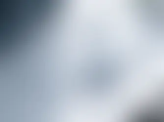 Peliohjain valkoisella pöydällä, ympärillä geometrisiä muotoja edustamassa eri peligenrejä sinisessä ja harmaassa