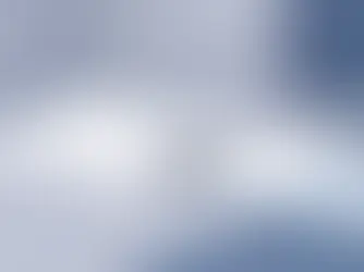 Peliohjain valkoisella pöydällä, ympärillä geometrisia muotoja sinisessä ja harmaassa, luonnollinen valaistus