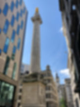 The Monument to the Great Fire of London in between modern buildings in London