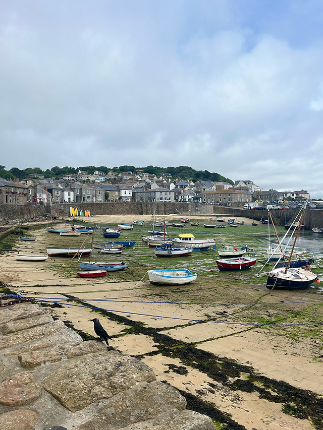 Quaint fishing boats docked in Mousehole harbour, Cornwall’s charming coastal village