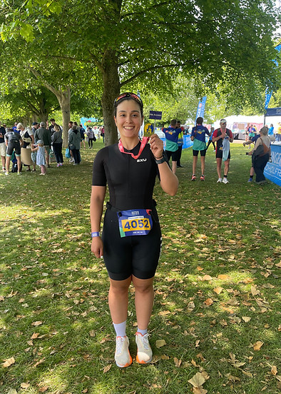 triathlete holding a medal at the end of a race
