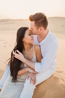Couple sitting on a dune in Al Khatim desert during couple photo shoot