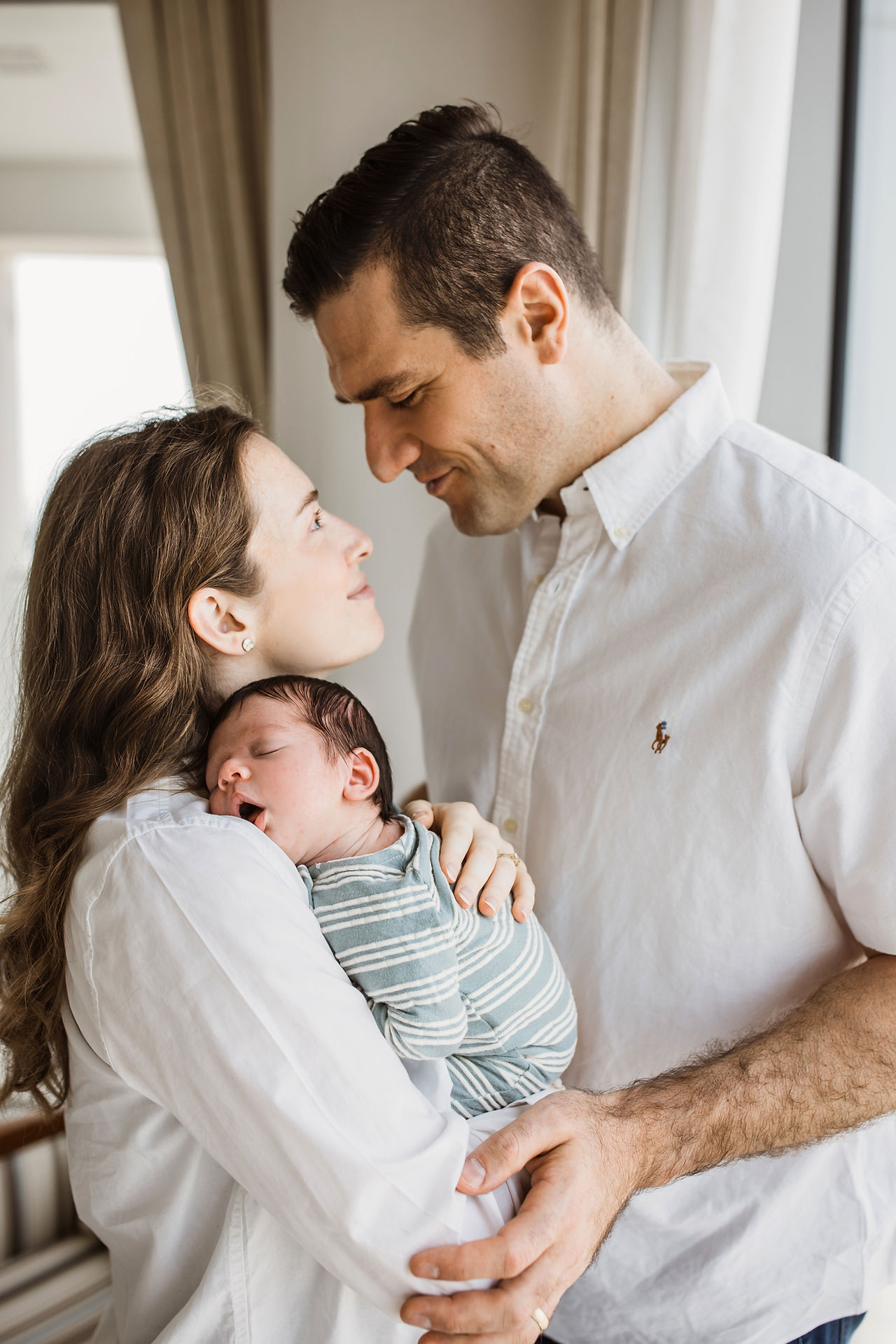 New parents holding baby during lifestyle newborn session in Abu Dhabi