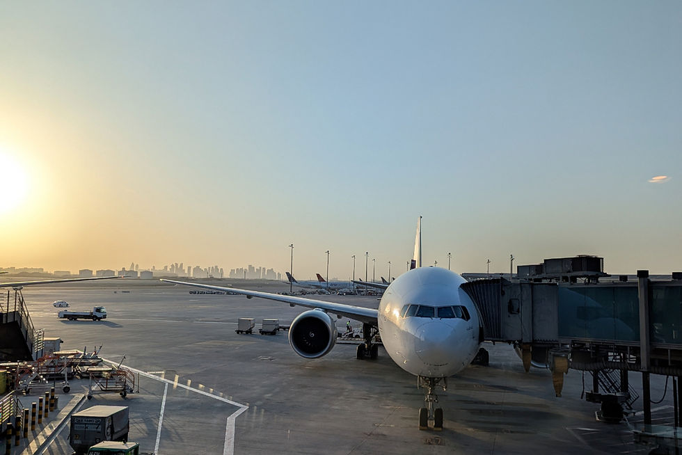 Qatar Airways have launched a new version of their reward seat finder. An airplane on runway with Doha skyline in background. Clear sky, water reflects city buildings. Majestic, modern ambiance.