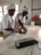 Workers sealing meat products with vacuum sealer