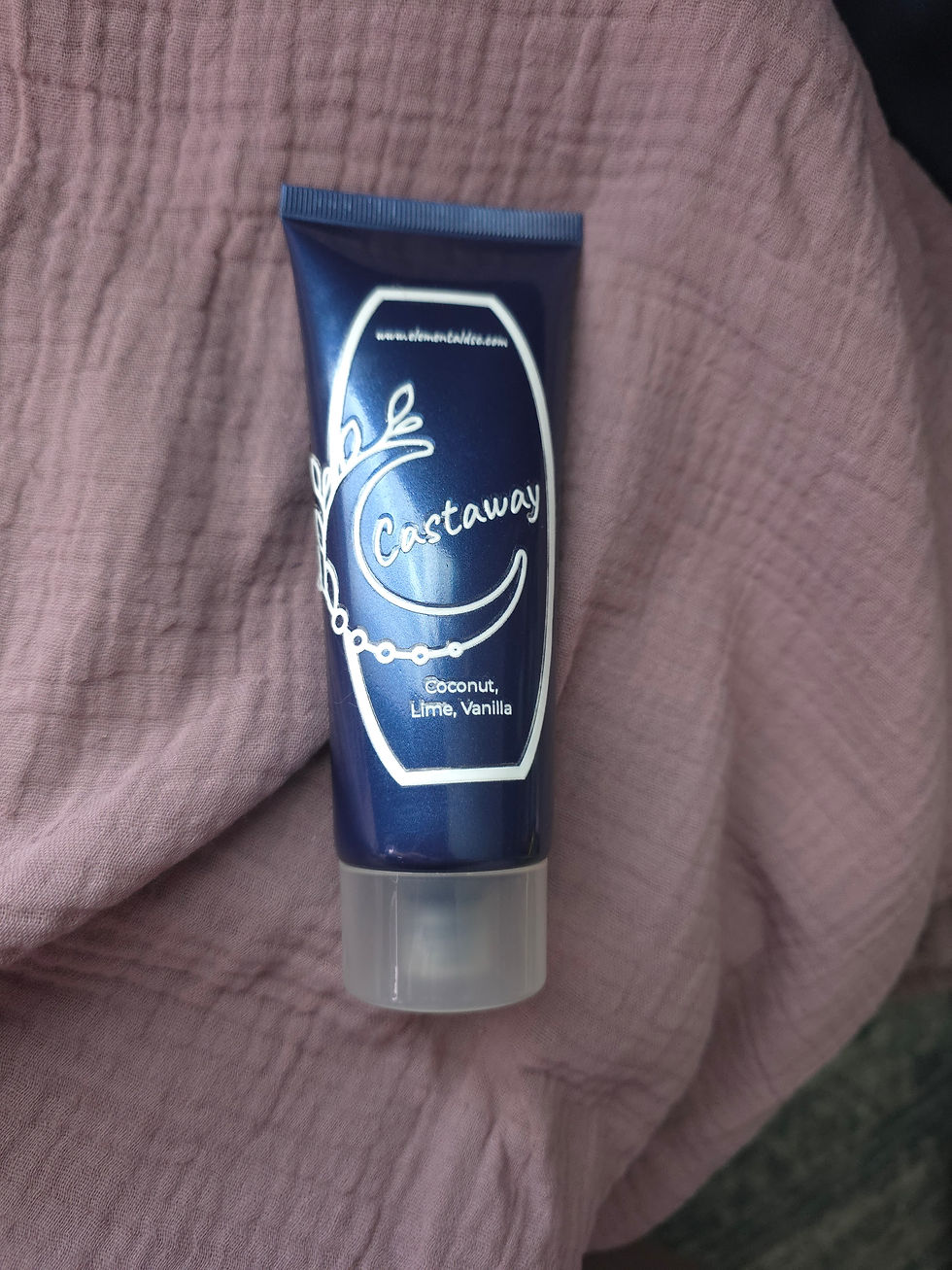 Thumbnail: Blue conditioner tube with white label on pink fabric surface