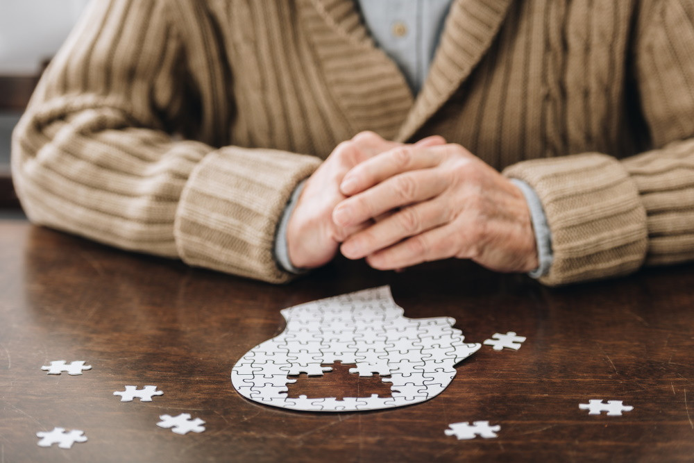 A senior man with an incomplete puzzle representing dementia