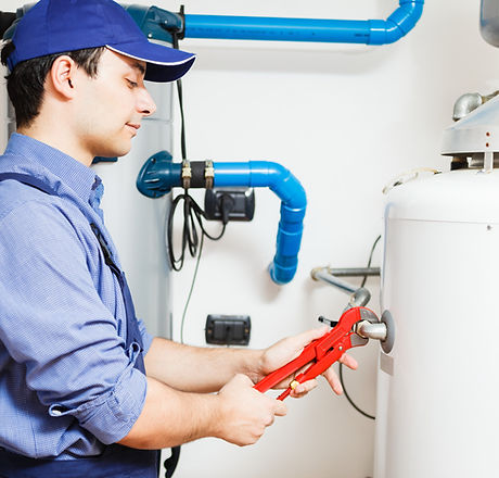 Engineer with wrench fixing boiler