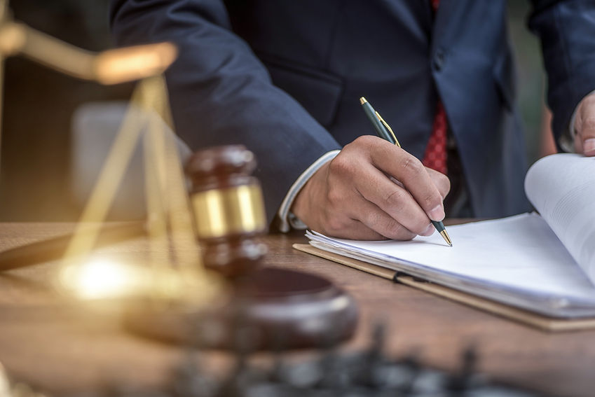Official's hand signing papers in court