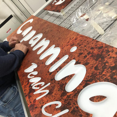 Pannello per insegna in forex con finitura fantasia e lettere incise su base in plexiglass opal bianco