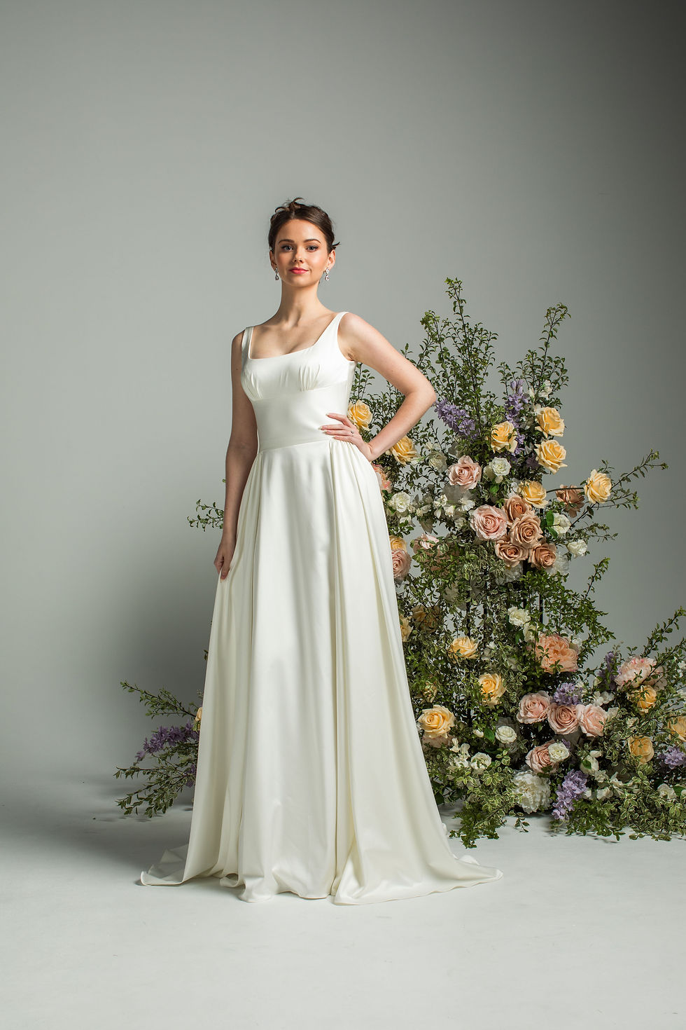 Thumbnail: Bride wearing ‘Innocence’ by Jean Fox satin wedding dress featuring a square scoop neckline, bustier bodice, and soft gathere