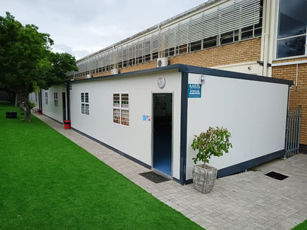 Modular classroom entrance beside an existing school building