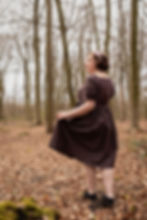 Modell in braunem Kleid im Wald