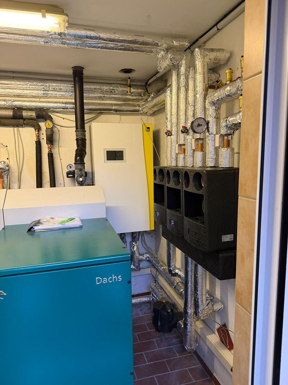 Der modernisierte Heizungsraum vereint die iDM Inneneinheit, das Blockheizkraftwerk (BHKW) und die Heizkreisverteilung zu einem perfekt abgestimmten Energiesystem. Alle Komponenten arbeiten effizient zusammen und versorgen drei Einfamilienhäuser zuverlässig mit Wärme.
